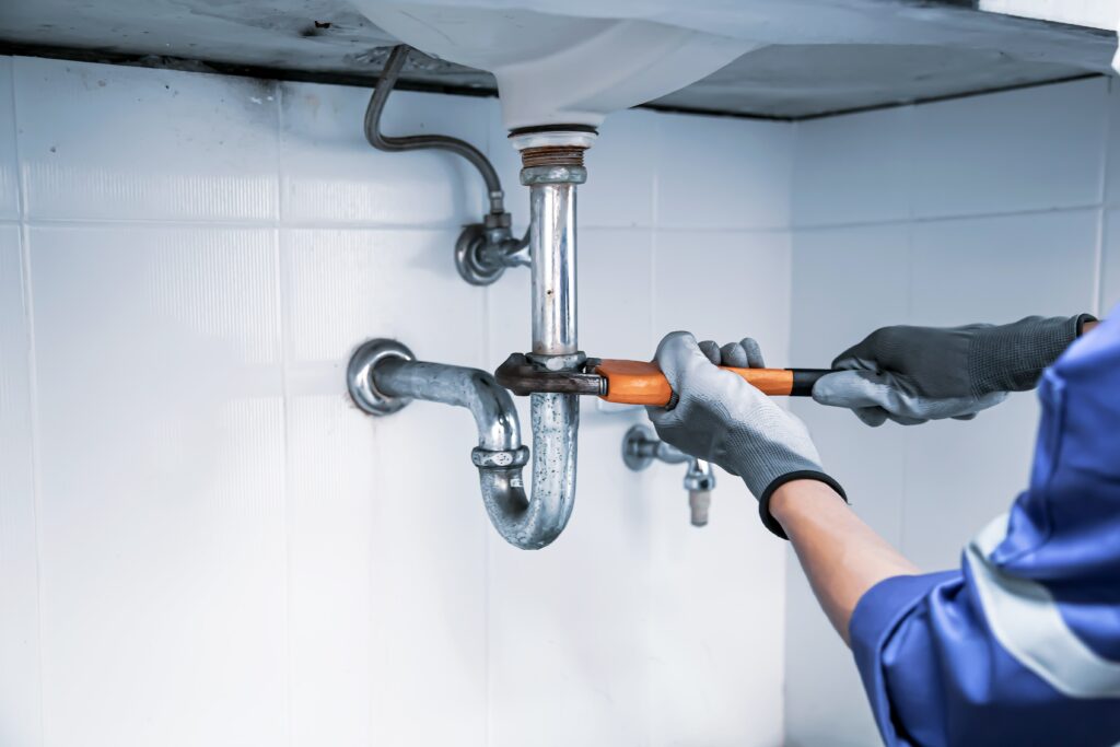 plumber-using-wrench-repair-water-pipe-sink-min - preventive plumbing tacoma wa